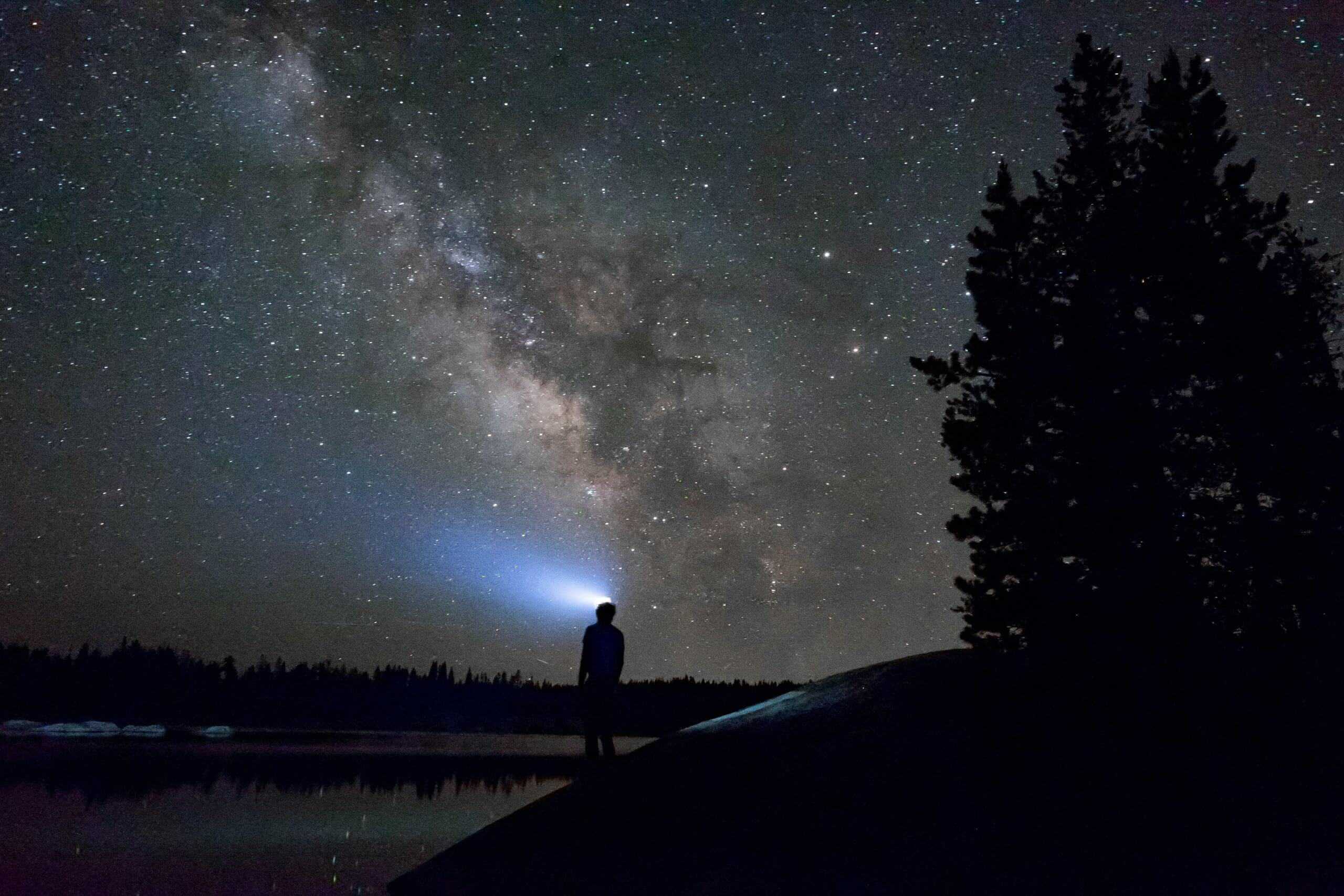 Person wearing best headlamp for fishing at night, looking at sky