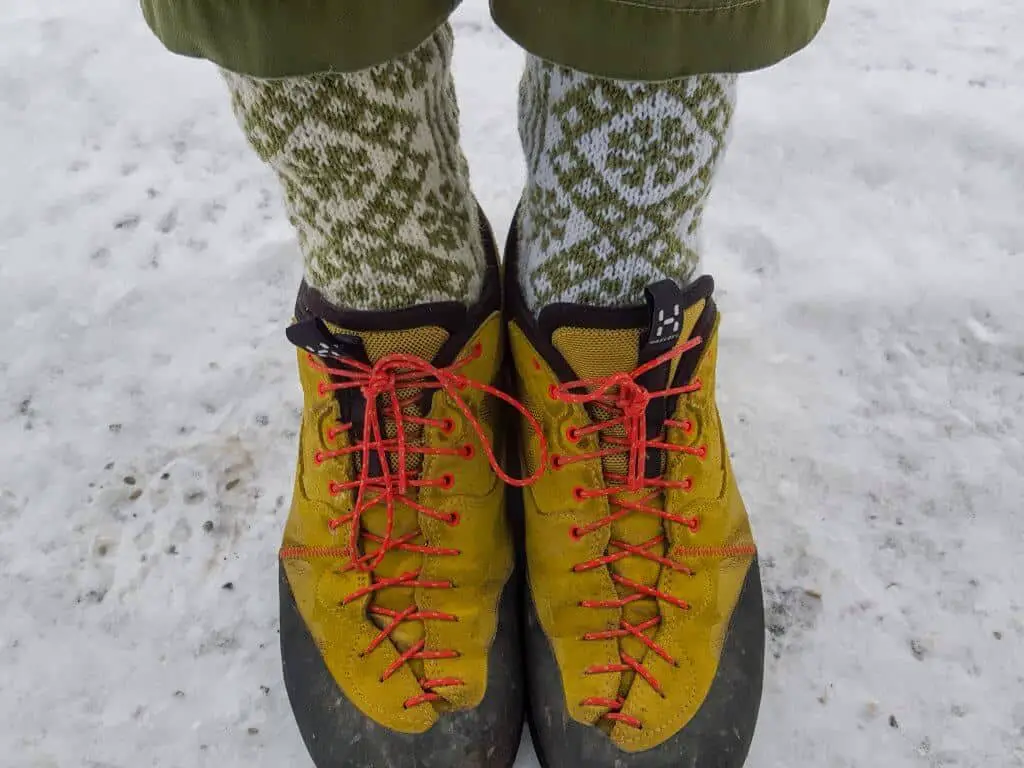 Woman wearing some of the best socks for ice fishing standing on frozen lake wearing winter boots