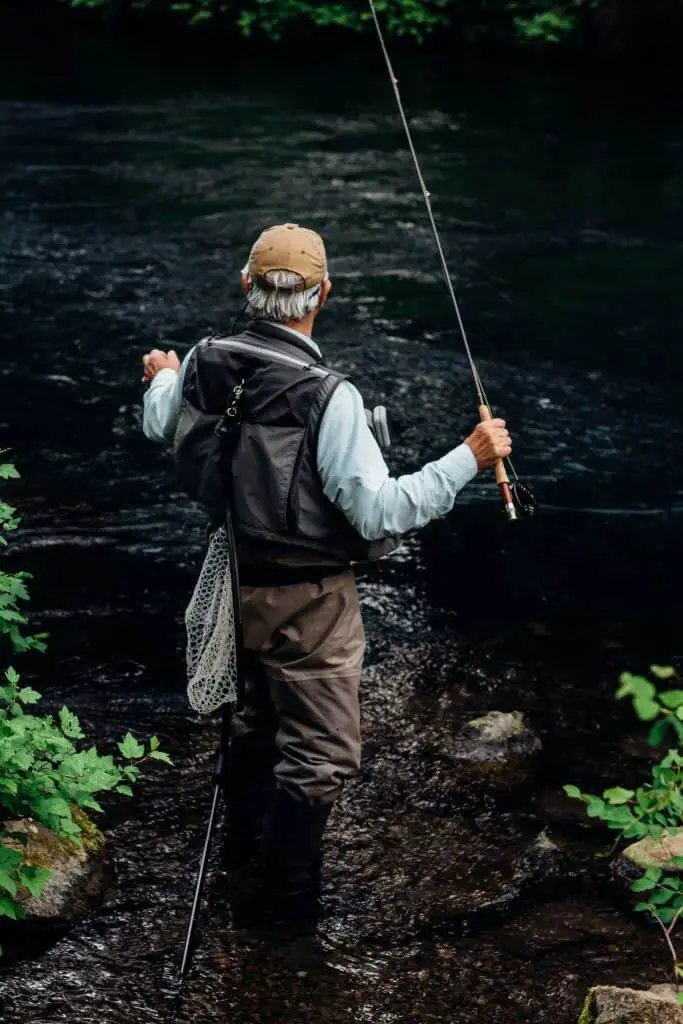 Man angling wearing best fly fishing vest