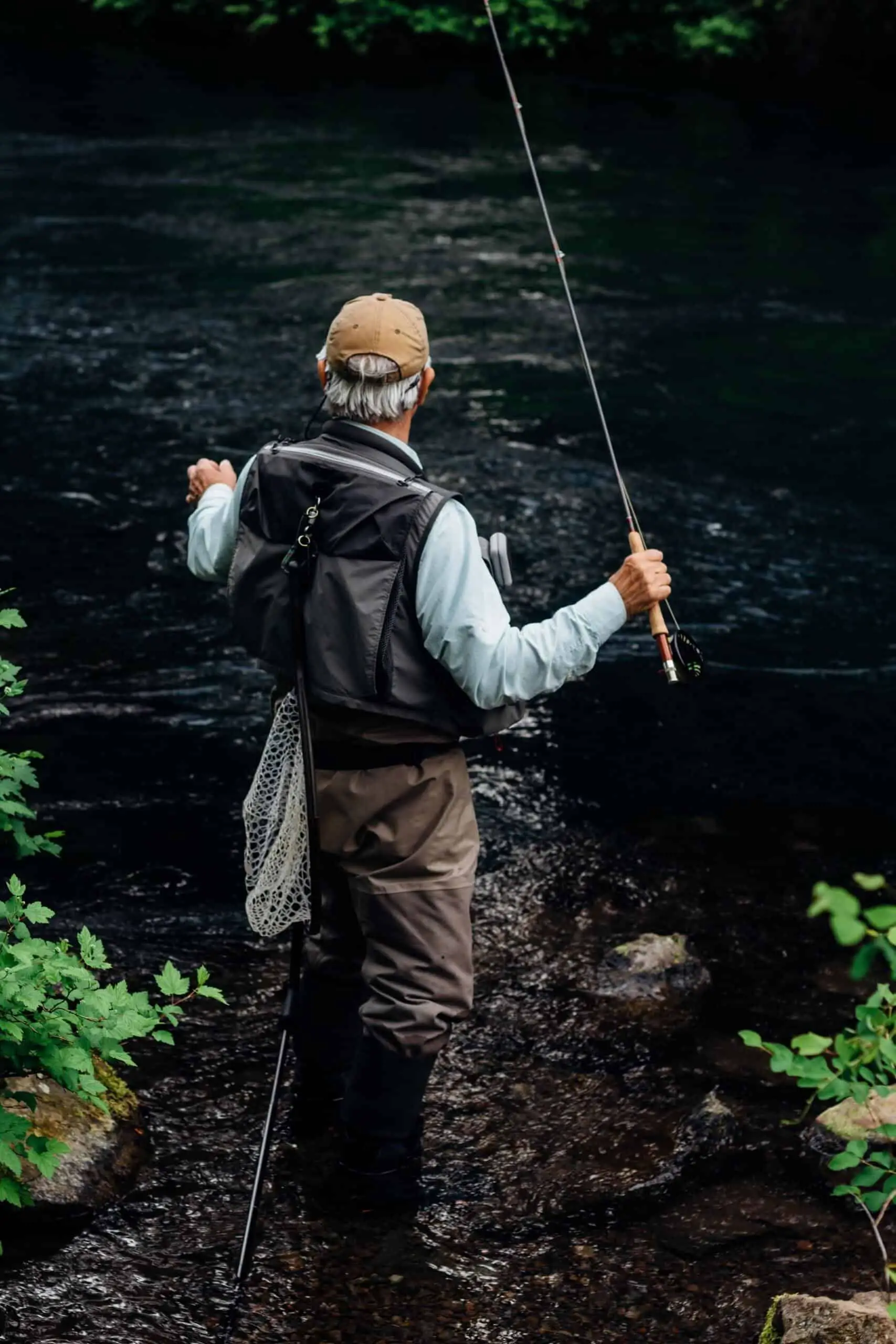 Man angling wearing best fly fishing vest