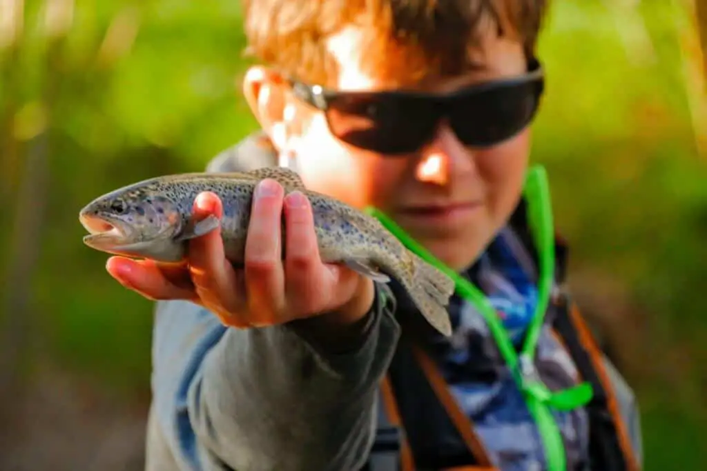 Boy holding fish wearing some of the best fishing sunglasses under $50