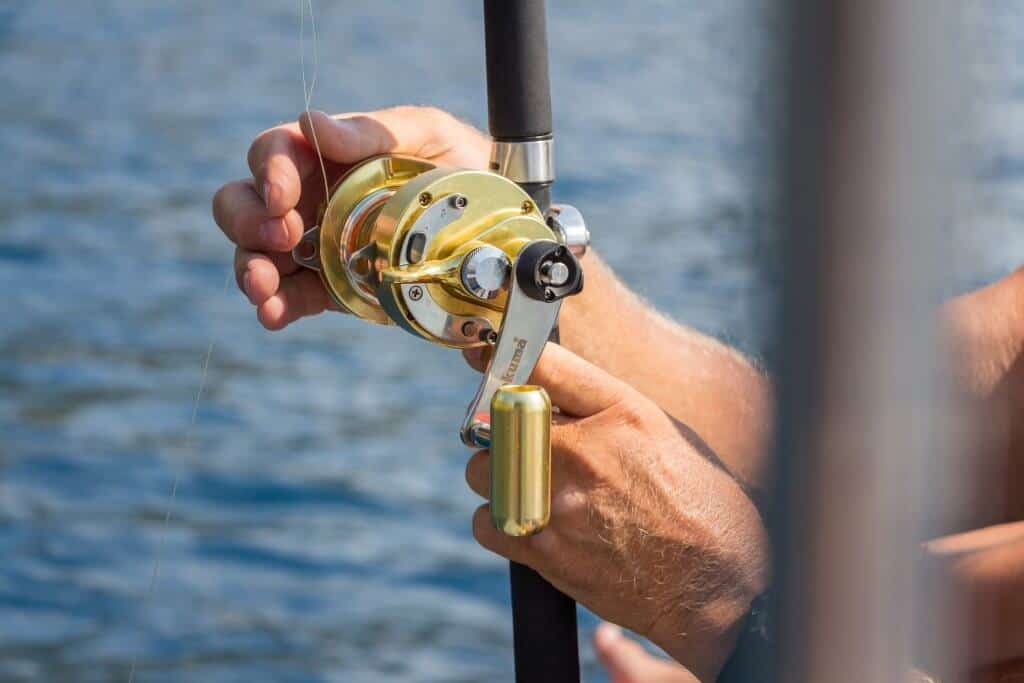 man holding one of the best salmon rod and reel combos in front of water in Greece