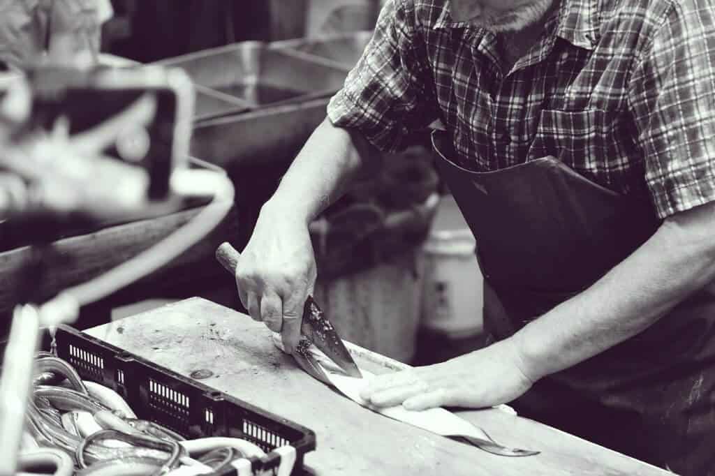 Man on Tsukiji Fish Market Cutting Fish with one of the best salwater fishing knife