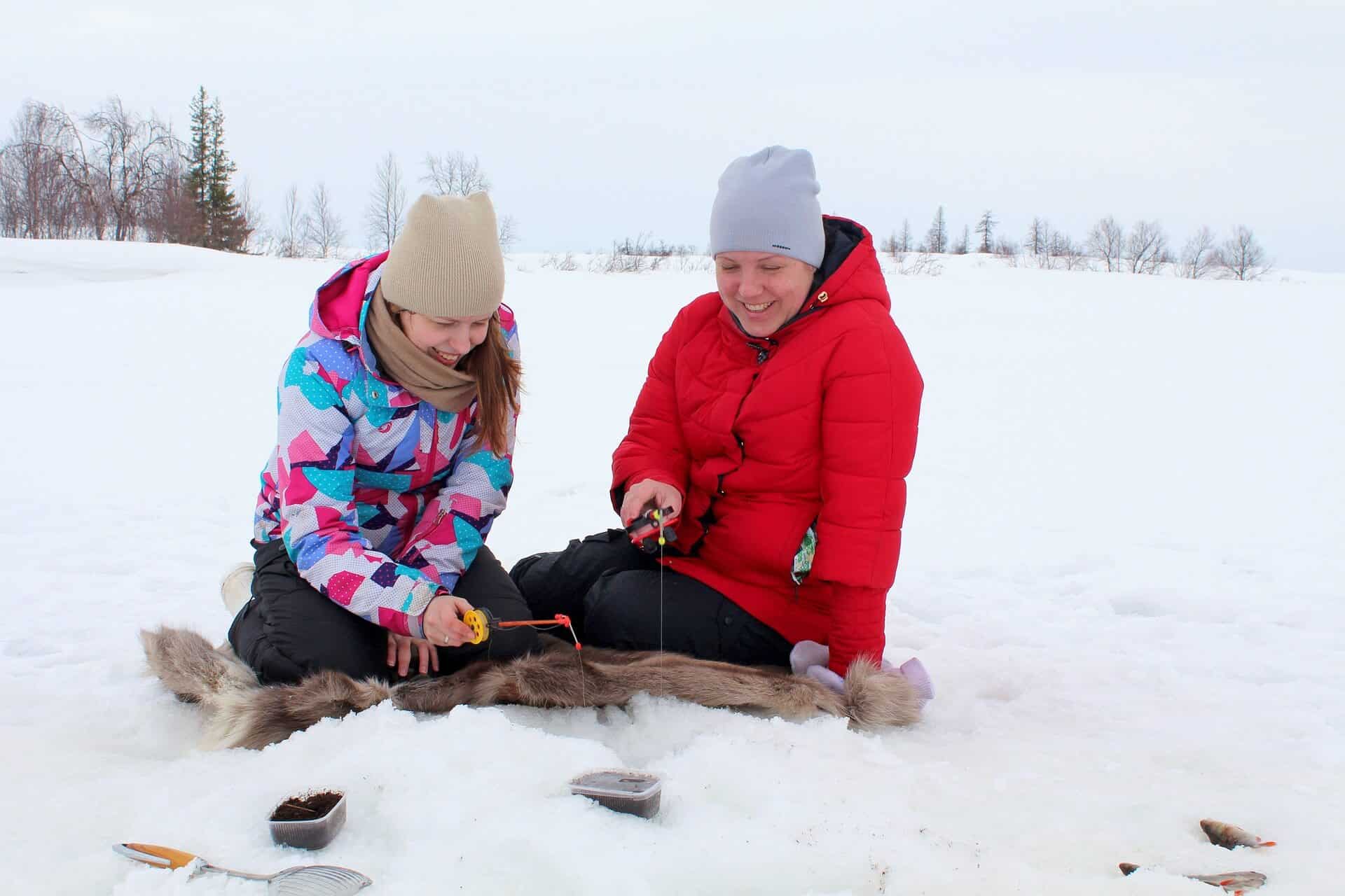 Two girls ice fishing, using some of the best ice fishing line