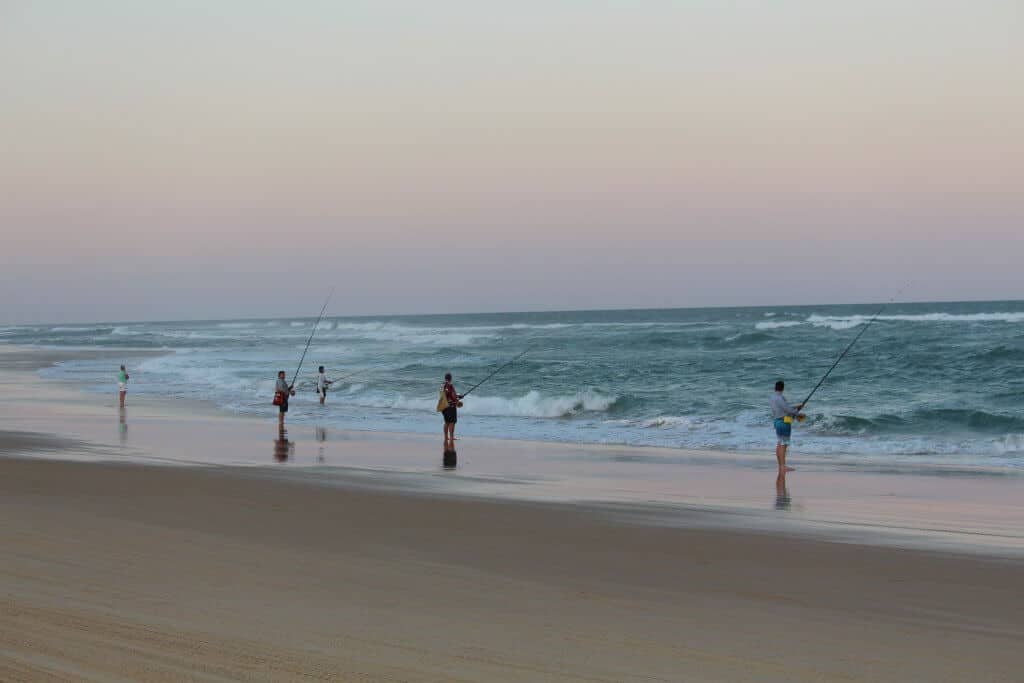 people fishing at ocean with some of the best saltwater reels and rods