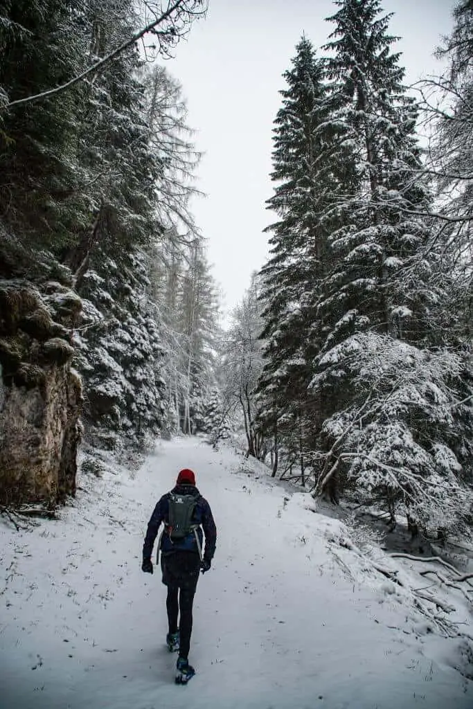 Man wearing thermal underwear walking in snow up a hill