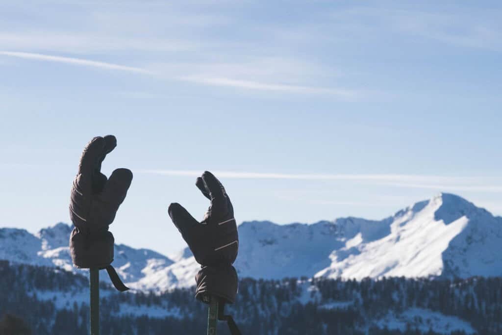 a pair of the best ice fishing gloves on sticks in snow