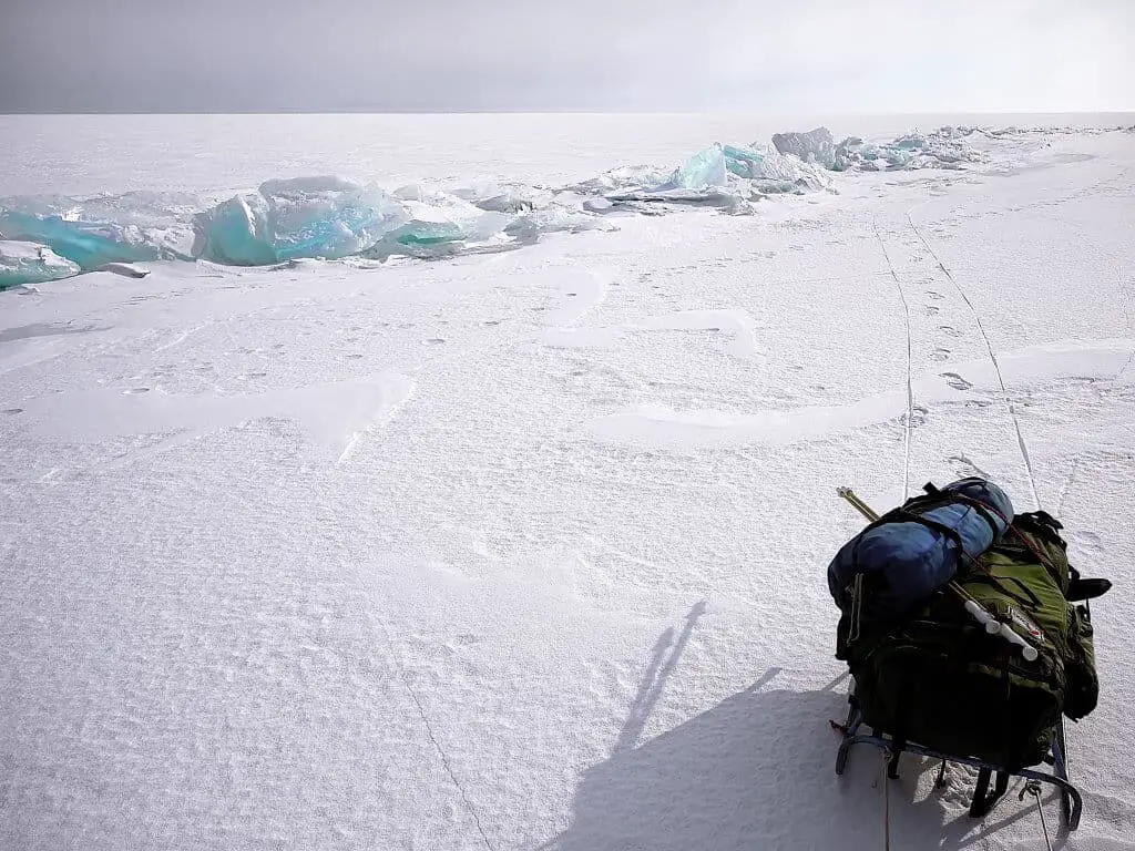 A backpack on a sled in the ice