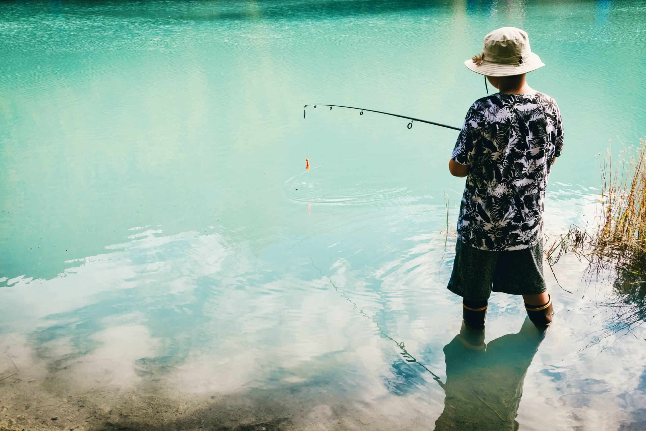 Young man wearing one of the best fly fishing hat to fly fish in a body of water