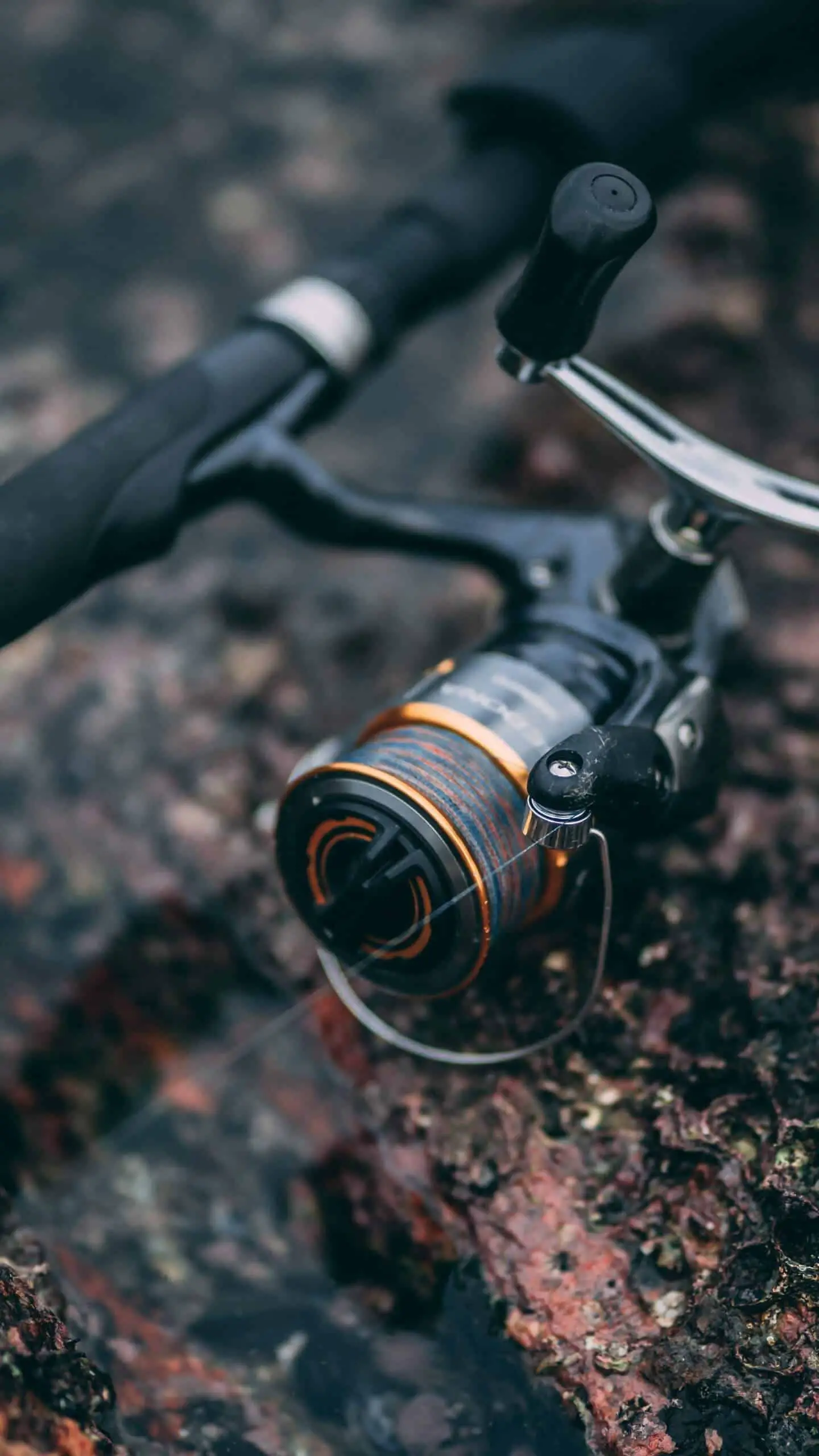 one of the best microspinning reel in black lying on the ground