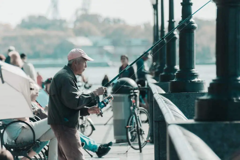 Fishing requires patience: an old man fishing from a pier