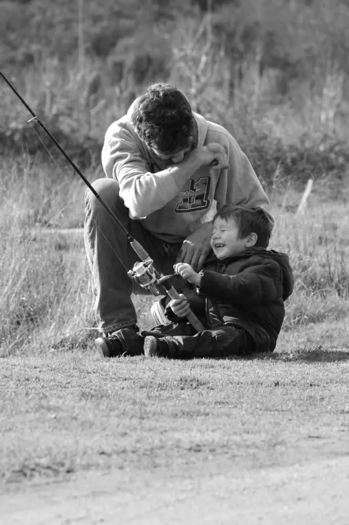 The future of fishing: father teaching young boy how to fish