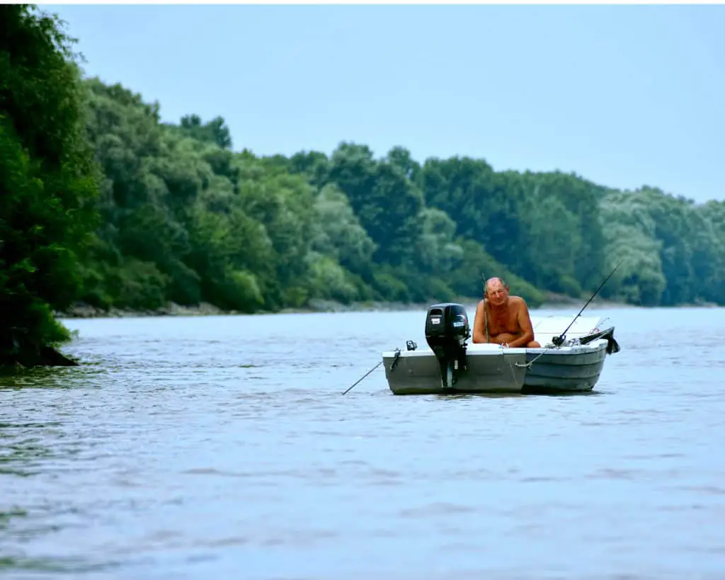 man on a boat on a lake fishing using one of the best finder for small boats