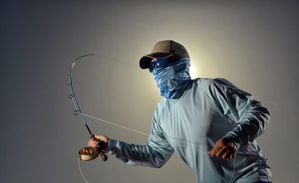 A young man casting while fishing in the morning