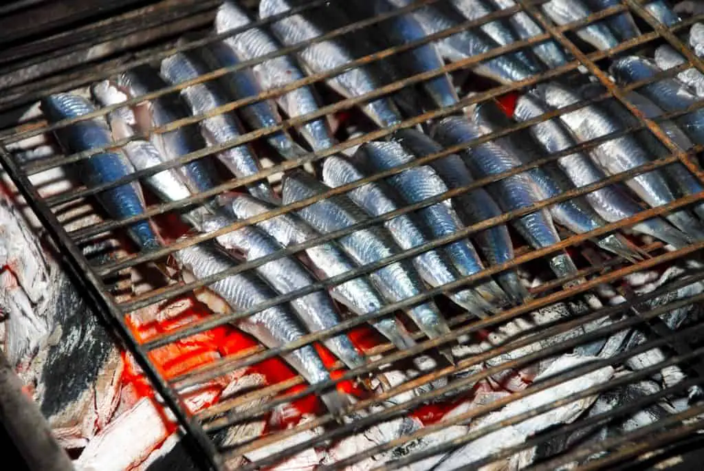 Anchovies on one of the best fish grilling baskets on charcoal different angle