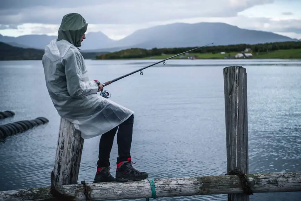 Man sitting in the rain while angling