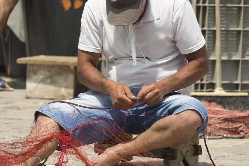 Fisherman repairs his net in Gallipoli (Le) in Souther Italy