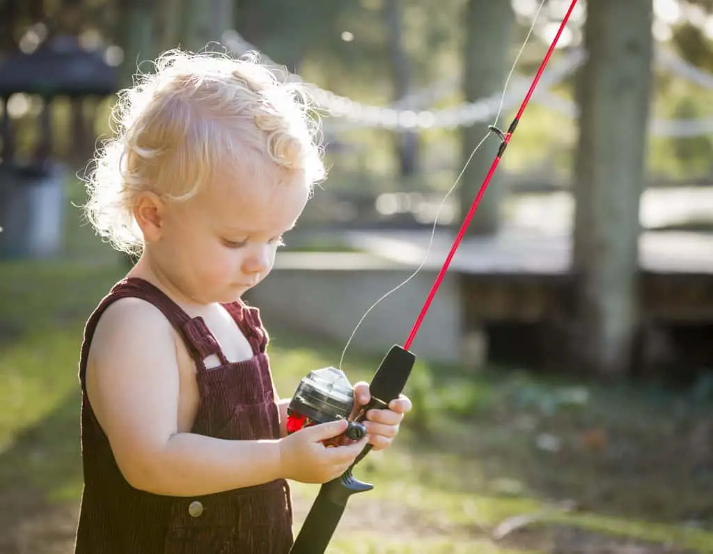 Cute Young Boy With Fishing Pole Outside at The Lake. Fishing with toddlers is fun!