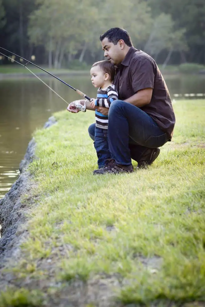 Happy Young Ethnic Father and Son Fishing at the Lake.