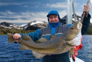 a man presenting a caught fish on a gaff fishing hook