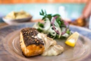 a fish fillet on a plate with mayo